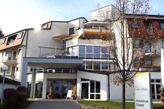 Eingang Seniorenzentrum St Elisabeth mit Balkonen und Baum