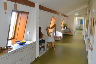 Heller Flur mit schrägen Dachfenstern, Sitzgelegenheiten und Schränken