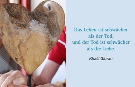 Holzherz in Händen links, rechts Zitat mit Autorenangabe